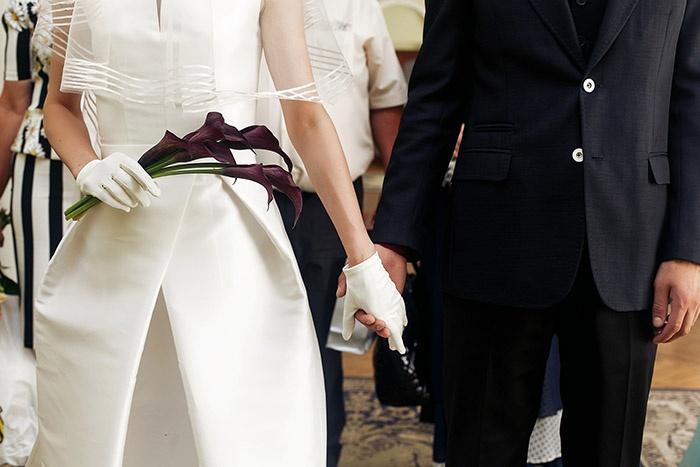 couple holding hands with bride wearing wrist length wedding gloves