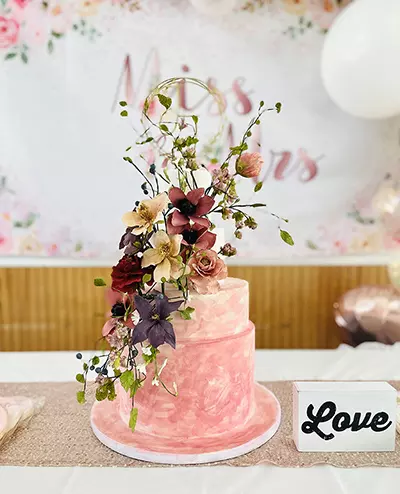 Pink tiered wedding cake, two tiers with flowers on