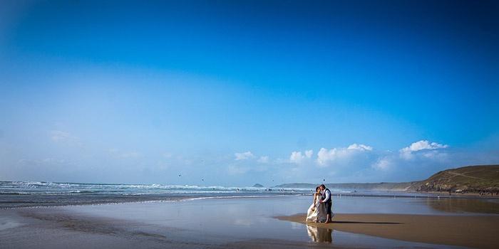Bride and groom kissing on Perranporth Beach, Cornwall, United Kingdom