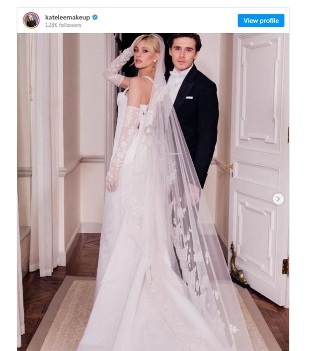 Nicole Peltz standing in white wedding dress with veil and lace opera length gloves s
