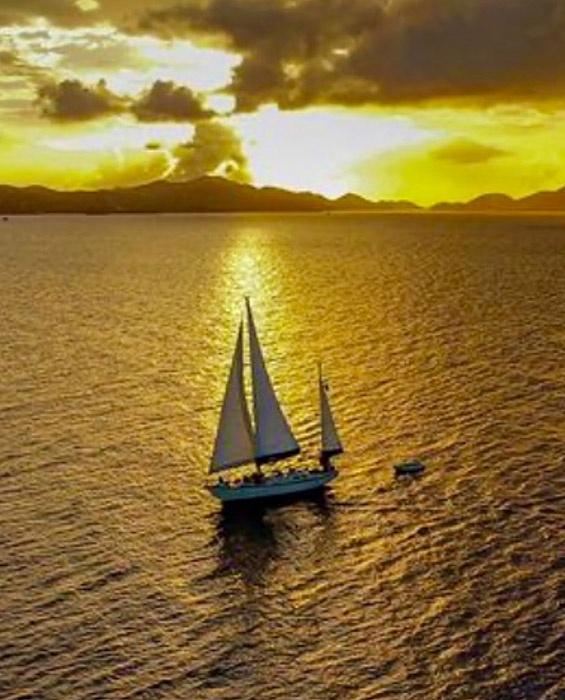 sail boat Helios sailing off the USVI at sunset